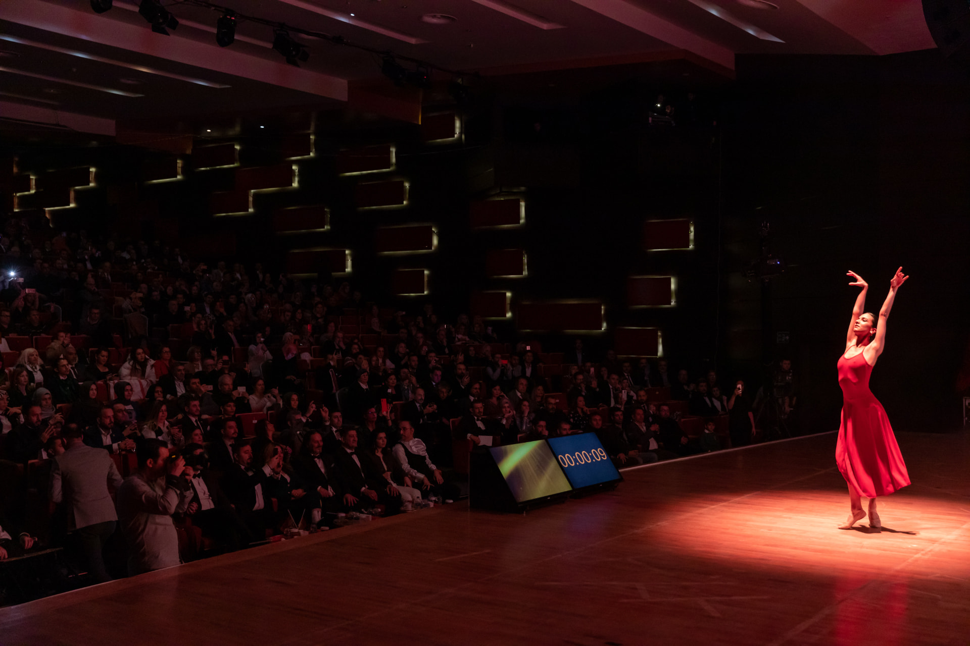 Kırmızı elbiseli dansçının sahne performansı